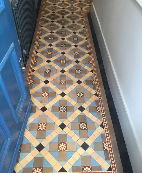 A view of a cleaned Victorian floor containing encaustic and plain blue and buff tiles